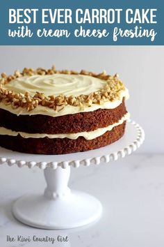 a cake with white frosting and walnuts on top is sitting on a plate