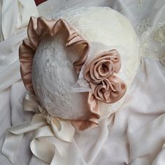 Lace christening bonnet. Cap in soft tulle base with Chantilly lace, champagne color. The interior is manufactured from soft cotton cloth. The bonnet shape at the front has a curly veil ruffle that contours its shape. On one side, the bonnet has small lace accents with two roses created and applied by hand. Ties with satin bows. DELIVERY AND RETURNS Please advise all products are ready-made, off the shelf and we offer very fast delivery with DHL. Processing time The time I need to prepare an ord Elegant Adjustable Cream Bonnet, Fitted White Bonnet For Baptism, White Fitted Bonnet For Baptism, Adjustable Cream Bonnet For Baptism, Adjustable Cream Bonnet As Gift, Adjustable Cream Bonnet As A Gift, Elegant Cream Wedding Bonnet, Lace Bonnet, Two Roses