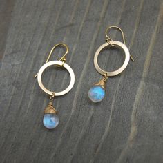 These delicate Moonstone teardrop earrings are hand wrapped in 14k gold filled wire, and dangle from an 18k gold filled flat hoop. The moonstone's iridescent nature is complimented by the delicate fine wiring. The magical milky blue luster glows from within the gemstone, and reflects beautifully in different lights.   Moonstone is known to channel hope, sensitivity and abundance by wearing it. It's properties are also known to enhance calmness and strength, while promoting inspiration and succes Minimalist 14k Gold Filled Teardrop Dangle Earrings, Gold Teardrop Hand Wrapped Jewelry, Gold Wire-wrapped Briolette Teardrop Earrings, Adjustable Teardrop 14k Gold-filled Hoop Earrings, Minimalist Wire Wrapped Teardrop Earrings, Minimalist Teardrop Wire Wrapped Earrings, Gold Moonstone Hand Forged Earrings, Gold Hand Forged Moonstone Earrings, Gold Hand-forged Moonstone Earrings