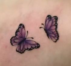 two purple butterflies on the back of a woman's stomach