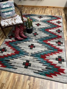 a chair and rug in a room with wooden floors, cactuses on the floor