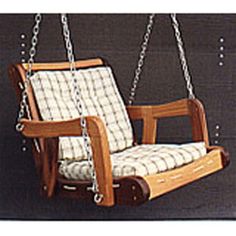 a wooden swing chair hanging from chains