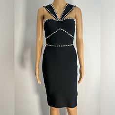 a mannequin dressed in a black dress with pearls on the neck and shoulders