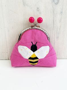 a pink purse with a bee on it