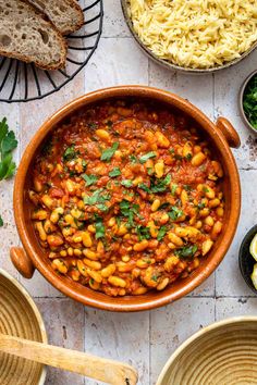 a large pot filled with pasta and garnished with parsley on the side