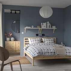 a bedroom with blue walls and white furniture