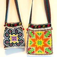 two purses are hanging on the wall next to each other with beaded designs