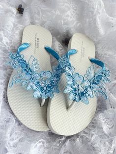 This beautiful white flip flops is wrapped with a blue mist ribbon, and adorned with a matching blue lace flower appliqué with sequins.  Ribbon color is blue if you are needing other colors of ribbon or decoration please contact me and will be happy to accommodate you! Matching hair comb: https://www.etsy.com/your/shops/me/listing-editor/edit/1688946289 All flip flops are handmade to order and the production time is 1 to 2 weeks and then please allow additional time for shipping. Amazing for bea Blue Summer Party Flip Flops, Blue Wedding Sandals, Blue Lace Flower, Bridesmaid Flip Flops, Wedding Flip Flops, Blue Flip Flops, White Flip Flops, Wedding Sandals, Womens Wedding Shoes