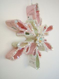 an ornament made out of pink and white shoes hanging from a hook on a wall