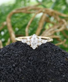 an engagement ring sitting on top of a pile of dirt