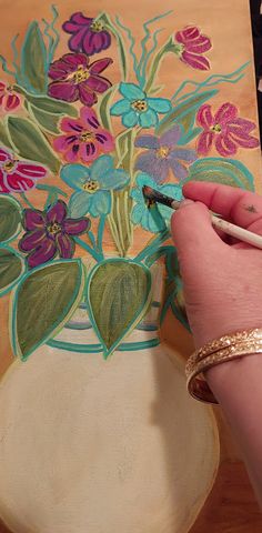 someone is painting flowers in a vase with colored pencils