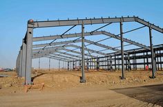 a large metal structure sitting on top of a dirt field