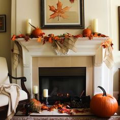 a fireplace decorated for fall with pumpkins, leaves and candles on the mantel