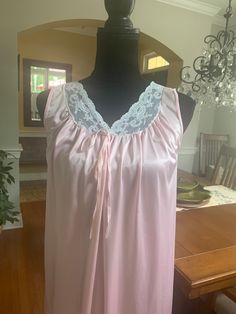 A summer beauty! A lightweight sleeveless nightgown with lace trim on the v-shaped neckline. Decorative tie at the bustling. In good vintage condition with no rips or stains. The bust measures 18 inches from armpit to armpit laying flat, 36.5 inches from shoulder to hem. Pinehurst. Made in the USA Nylon machine washable Lace Sleeveless Sleepwear For Pajama Party, Sleeveless Lace Sleepwear, Sleeveless Lace Nightgown For Pajama Party, Pink Lace Camisole Nightgown, Pink Sleeveless Vintage Nightgown, Vintage Pink Sleeveless Nightgown, Sleeveless Lace Nightgown For Home, Pink Sleeveless Nightgown For Bedtime, Lace Nightgown With Lace Trim For Pajama Party