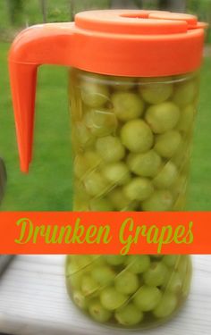 a jar filled with green grapes sitting on top of a table