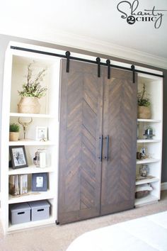 a large wooden door in the middle of a room with shelves and pictures on it