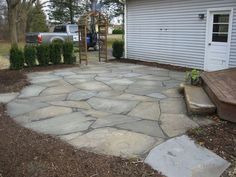 a stone patio in front of a house