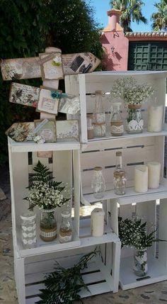 a white shelf filled with lots of vases and plants on top of it's sides