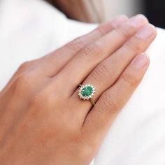 Ring with Emerald and Brilliants in Gold | KLENOTA Emerald And Diamond Engagement Rings, Luxury Green Oval Cluster Ring, Green Oval Diamond Halo Ring, Oval Green Diamond Halo Ring, Elegant Green Oval Halo Ring, Oval Green Emerald Ring For Proposal, Oval Green Emerald Proposal Ring, Oval Green Diamond Ring For Proposal, Oval Emerald Ring With Diamond For Proposal