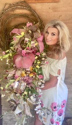 a woman standing next to a vase filled with flowers