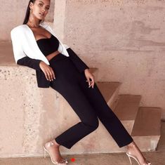 a woman in black and white is sitting on some steps