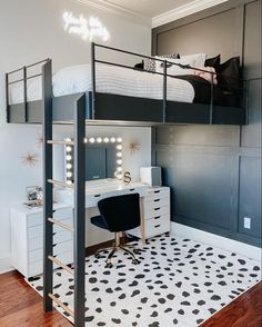 a bedroom with a loft bed, desk and chair next to a white dresser in the corner