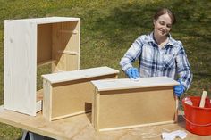 a woman in blue gloves standing next to two boxes on top of a wooden table