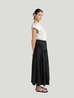 Revamp your fashion with our elevated midi skirt, boasting delicate pintuck pleats and a raw textured edge at the waist. Combining practicality and sophistication, this versatile piece features convenient pockets and an easy side zipper. Crafted with 100% organic cotton and handmade in India, it adds a touch of elegance to any outfit. Care for it by machine washing on delicate, laying it flat to dry, and warming it with an iron as needed. Additional Details: Product Type: Black Skirt Product Style: High Waisted, Material: Organic Cotton Fit: High Waisted, Flowy, Relaxed Fit Function: Everyday Wear, Casual Women-owned brand Eco-Conscious Brand Workwear Midi Length Pleated Skirt With Elastic Waistband, Pleated Midi Skirt With Elastic Waistband For Work, Workwear Pleated Skirt With Elastic Waistband, Workwear Full Pleated Skirt With Elastic Waistband, Pleated Tiered Skirt For Daywear, Tiered Skirt With Pleated Waist And Voluminous Fit, Daywear Tiered Pleated Skirt With Lining, Flowy Pleated Skirt With Elastic Waistband For Work, Relaxed Fit Tiered Maxi Skirt With Pleated Waist