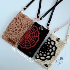 three crocheted cell phone cases with lanyards attached to each other on a white surface