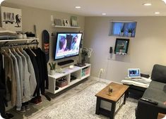 a living room filled with furniture and a flat screen tv sitting on top of a wall