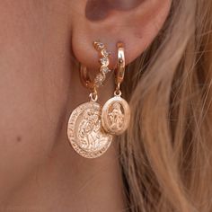 "Traveler's coin earrings, made with the holy Patron Saint Christopher coin earrings. Statement gold hoop earrings featuring a large round saint Christopher protection disc pendant suspended from a studded gold hoop earrings. Inspired by the Roman coin jewelry, we've created statement Traveler's Coin earrings. The huggie hoop is detailed with gorgeous zirconia diamonds and gold balls, creating a dramatic yet subtle touch the every hoop. The crystal detailed hoops are custom made for our shop, so Roman Coin Jewelry, Dainty Hoop Earrings, Statement Hoop Earrings, Stacked Earrings, St Christopher, Saint Christopher, Coin Earrings, Disc Pendant, Coin Jewelry