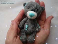 a hand holding a small crocheted teddy bear