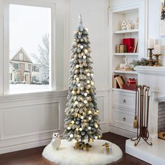 a decorated christmas tree in front of a window with white and silver decorations on it