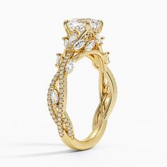 a yellow gold engagement ring with diamonds on the sides and an oval shaped center stone