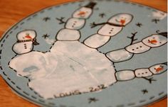 a hand made out of paper with snowmen on it