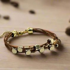 Get ready to elevate your wrist game with this multi-strand leather bracelet. Featuring gold-plated floating beads and a lobster clasp closure, this timeless piece is the perfect way to add a touch of sophistication to any outfit. Length: 6.5" + 1.5" extender chain - for an adjustable fit Lobster clasp closure - for a secure fit 6 strands of brown leather - for the perfect boho vibe 18K PVD Gold plated stainless steel - long lasting plating and hypoallergenic Handmade in China - to bring you the Adjustable Gold Leather Bracelet Chic Style, Adjustable Gold Leather Chic Bracelet, Adjustable Gold-tone Metal Beaded Bracelet, Trendy Adjustable Multi-strand Jewelry, Elegant Multi-strand Adjustable Wrap Bracelet, Adjustable Multi-strand Metal Bracelets, Gold Adjustable Double Strand Beaded Bracelets, Gold Wrap Bracelet Fashion Accessory, Adjustable Gold Leather Wrap Bracelet