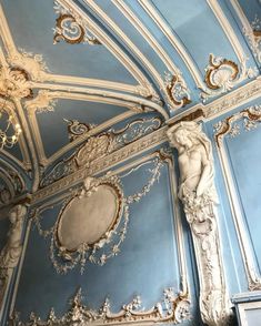 an ornately decorated room with blue walls and gold trimmings on the ceiling