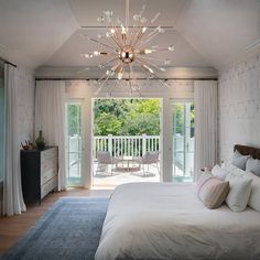 a bedroom with a bed, dresser and sliding glass doors leading to a patio area