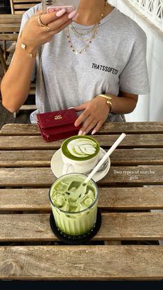 a woman sitting at a wooden table with a cup of green tea in front of her