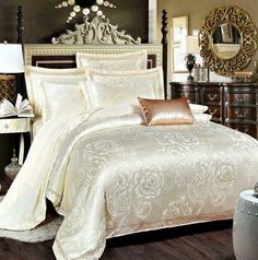 a bed with white and gold comforters in a bedroom