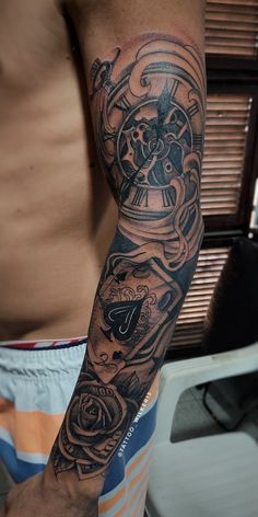 a man with a clock and roses tattoo on his arm