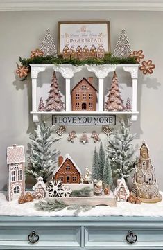 a christmas display with gingerbread houses, trees and snowflakes on the mantle