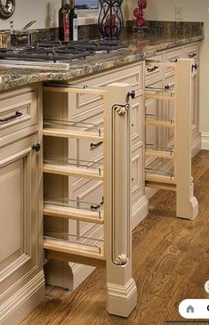 a kitchen with white cabinets and marble counter tops