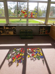 the sun shines through stained glass windows in an empty room with bookshelves