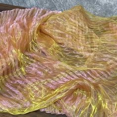 a yellow and pink piece of cloth on top of a wooden table