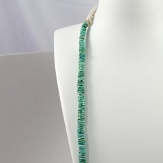 Single Strand Bead Necklace with Hand Rolled Heishi Beads made from Natural Carico Lake Turquoise from Nevada. The necklace is finished with a traditional cotton wrap and Ray Lovato’s signature “sing stone” tied into the back of the necklace.This necklace is made entirely from natural turquoise and you can expect the color of the turquoise to deepen over time.Number of Strands: 1Necklace Length: 31”