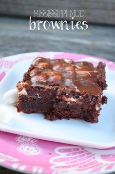 chocolate brownies with marshmallows are on a pink and white plate