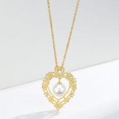 Vintage Hollow Heart Freshwater Pearl Pendant Necklace This elegant Vintage Hollow Heart Freshwater Pearl Pendant Necklace features a 7-8mm pearl set in a gold vermeil pendant. The timeless design and high-quality materials make it a perfect addition to any jewelry collection. Add a touch of vintage charm to your style while enjoying the natural beauty and elegance of freshwater pearls. Necklace Chain, material 925 sterling silver Length: 40cm with an extension of 5cm Product Information Pearl T Elegant Gold Jewelry With Pearl Charm, Gold Heart Necklace For Wedding With Round Pendant, Elegant Gold Plated Gold Pearl Necklace, Elegant Silver Heart Necklace With Pearl Charm, Gold Heart Necklace With Pearl Charm For Valentine's Day, Exquisite Gold Pearl Necklace For Anniversary, Classic Pearl Necklace For Anniversary And Mother's Day, Elegant Gold Necklace For Her, Pearl Heart Pendant Necklace With Clavicle Chain