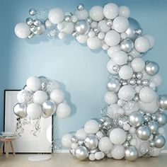 the balloon arch is decorated with silver and white balloons