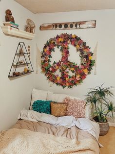 a bedroom with a bed, pillows and wreath on the wall above it is decorated with flowers